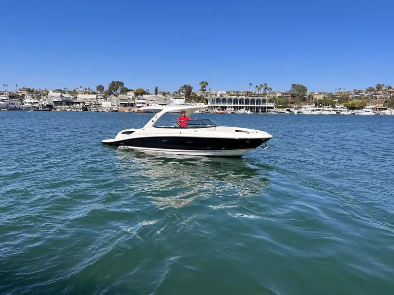 Slide: The Image of 2015 Sea Ray SLX 350 on calm water near coastal town. - 4