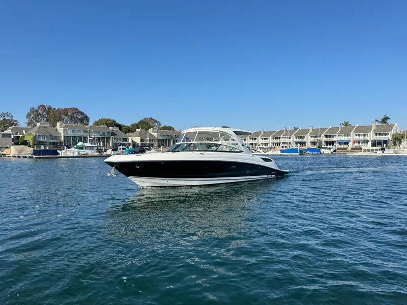 Slide: The Image of 2015 Sea Ray SLX 350 boat on calm water near coastal homes. - 8