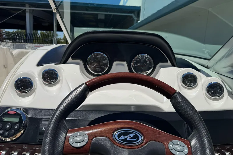 Slide: The Image of Dashboard of a 2007 Sea Ray SLX 250 boat with gauges and steering wheel. - 15