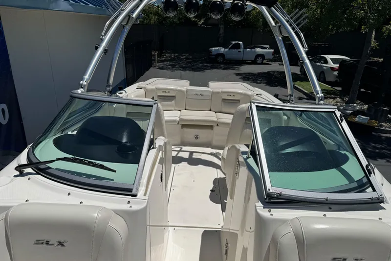 Slide: The Image of 2007 Sea Ray SLX 250 boat interior with seating and windshield, parked outdoors. - 18