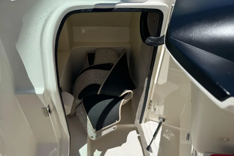 Slide: The Image of Storage compartment in a 2007 Sea Ray SLX 250 boat, featuring cushions and accessories. - 34