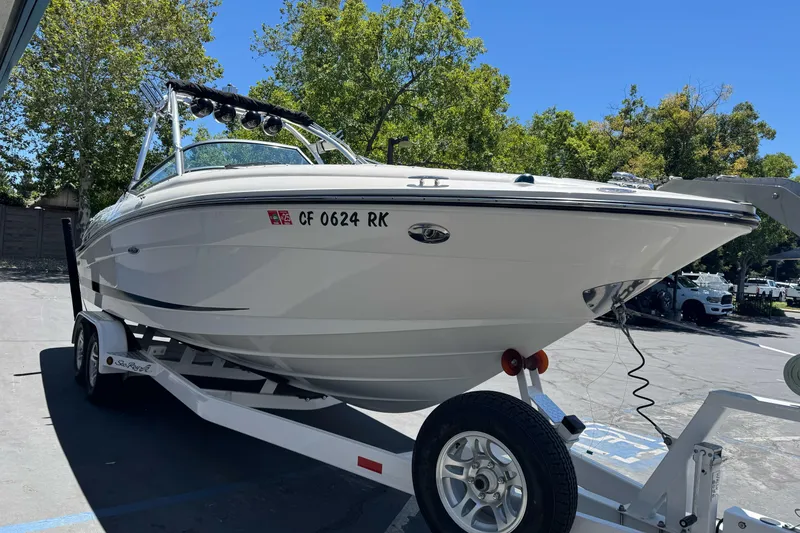 Slide: The Image of 2007 Sea Ray SLX 250 boat on trailer, parked outdoors under clear blue sky. - 4