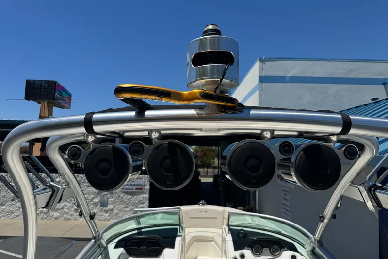 Slide: The Image of 2007 Sea Ray SLX 250 boat with mounted speakers and wakeboard tower under clear blue sky. - 46
