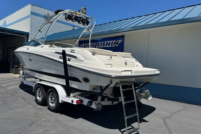 Slide: The Image of 2007 Sea Ray SLX 250 boat on trailer, parked outdoors near a building. - 7
