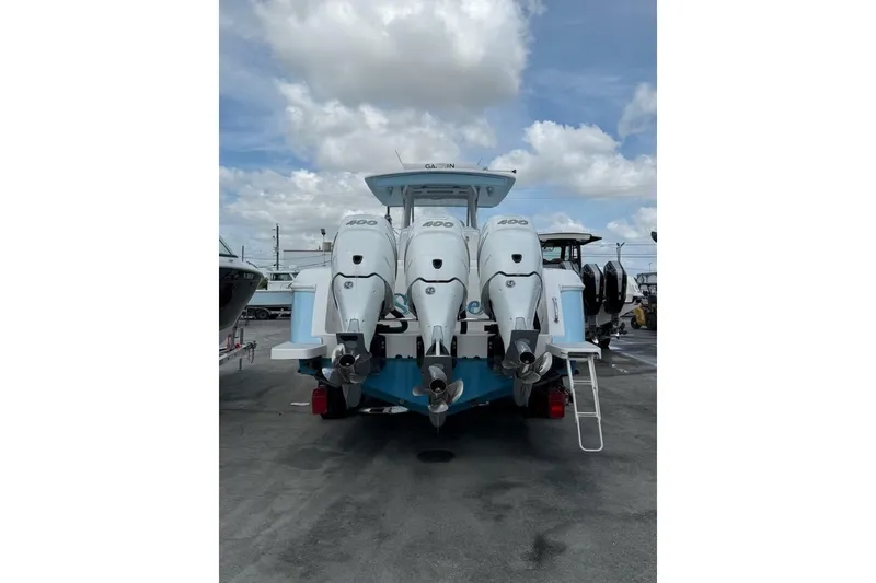 Slide: The Image of 2020 Intrepid 375 Nomad SE with triple 400 horsepower engines, docked under a cloudy sky. - 11