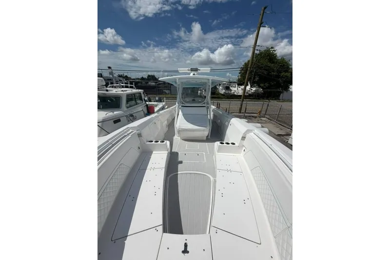 Slide: The Image of 2020 Intrepid 375 Nomad SE boat with spacious deck under a clear blue sky. - 4