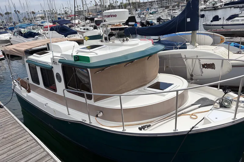 Slide: The Image of 2008 Ranger Tugs R-25 docked in a marina, surrounded by other boats. - 1