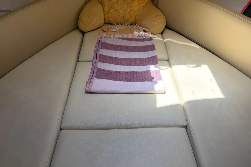 Slide: The Image of Interior of 2008 Ranger Tugs R-25 boat with beige cushions and striped towel. - 11