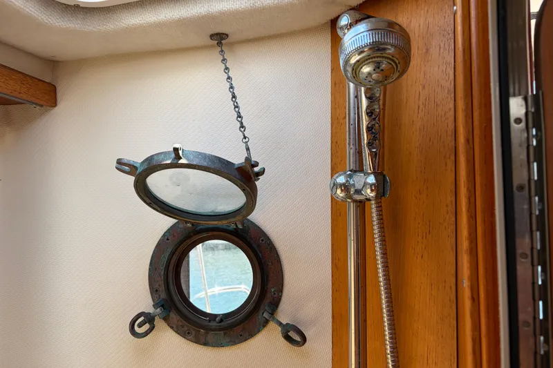 Slide: The Image of Porthole and shower fixture inside a 2008 Ranger Tugs R-25 boat cabin. - 13