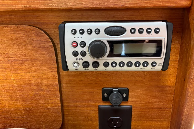 Slide: The Image of 2008 Ranger Tugs R-25 cabin stereo system with wood paneling background. - 14