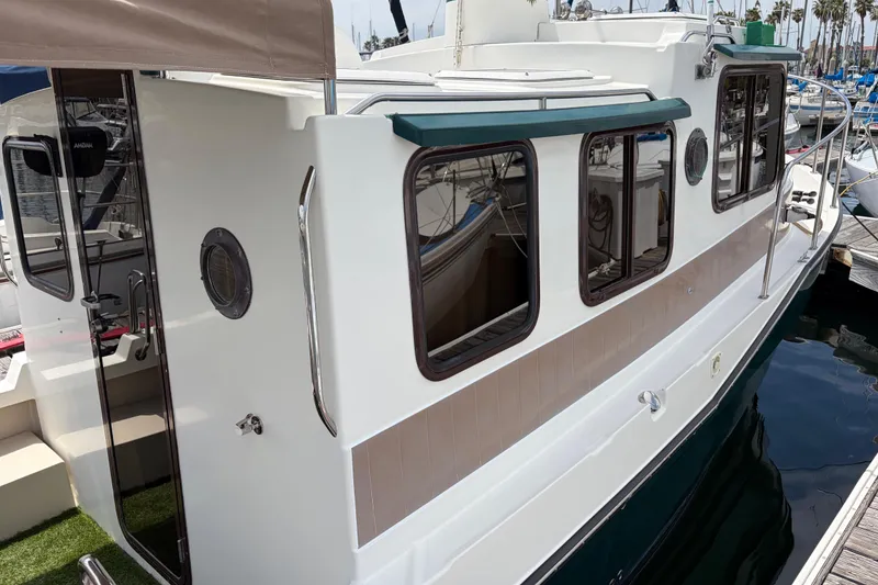 Slide: The Image of 2008 Ranger Tugs R-25 boat docked, showcasing side view and cabin windows. - 3