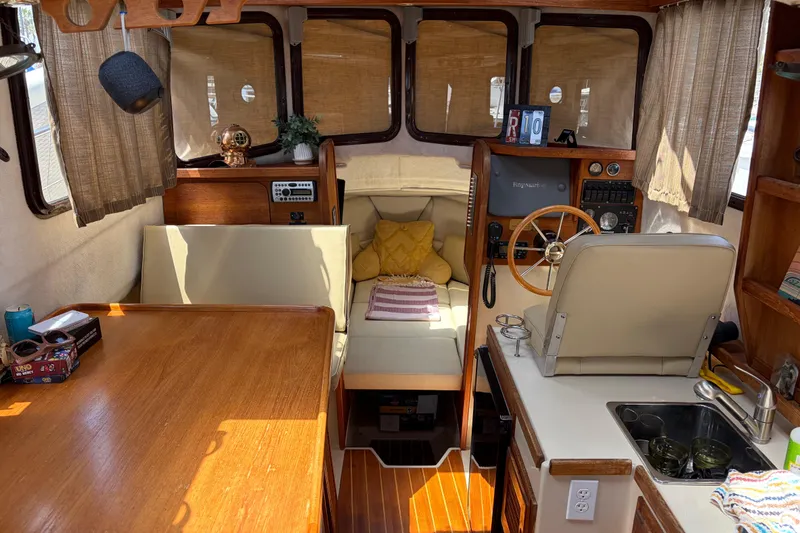 Slide: The Image of Interior of a 2008 Ranger Tugs R-25 boat with cozy seating and wooden accents. - 8