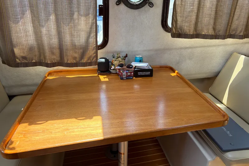Slide: The Image of Interior of 2008 Ranger Tugs R-25 with wooden table and cushioned seating. - 9