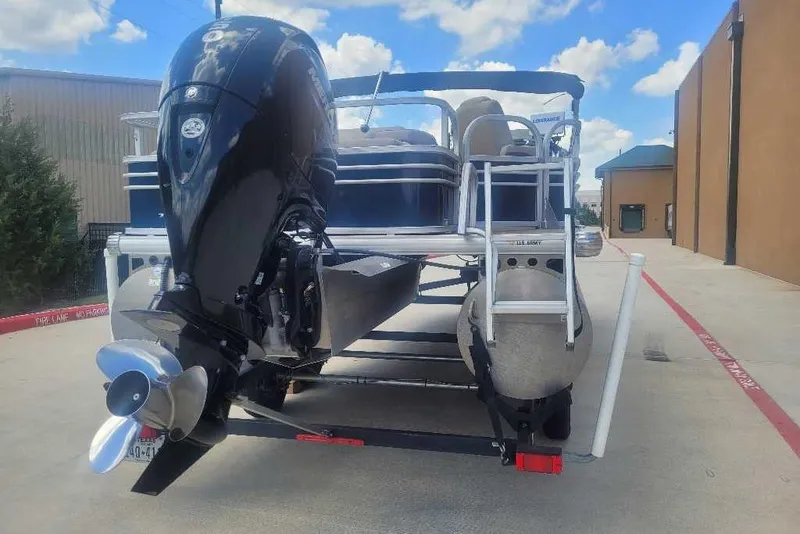 Slide: The Image of 2022 Sun Tracker Fishin' Barge 22 DLX pontoon boat with outboard motor on trailer. - 4