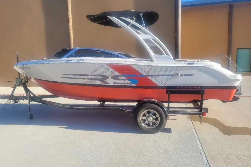 The Image of 2016 Four Winns H200RS boat on trailer, featuring sleek design and vibrant red accents. - 0