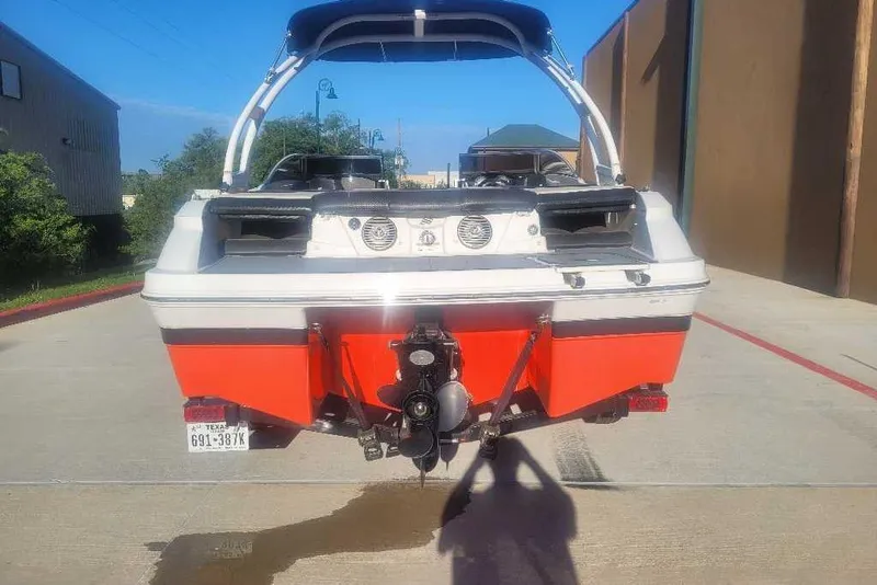 Slide: The Image of 2016 Four Winns H200RS boat, rear view, parked on concrete, vibrant orange hull. - 5