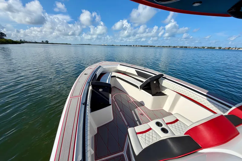 Slide: The Image of 2023 Statement 350 Open boat interior with red and white seating on calm water. - 17