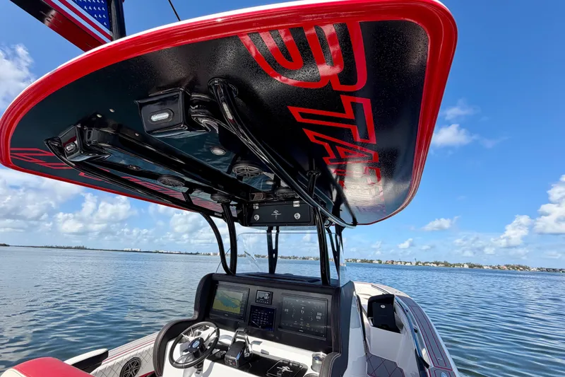 Slide: The Image of 2023 Statement 350 Open boat dashboard with advanced controls, under a sleek red canopy. - 22