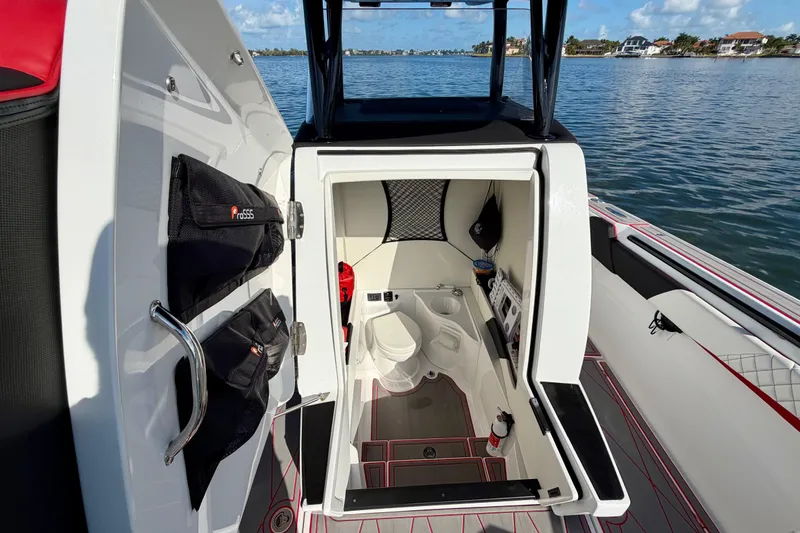 Slide: The Image of 2023 Statement 350 Open boat interior with storage compartments and seating, docked on a sunny day. - 26