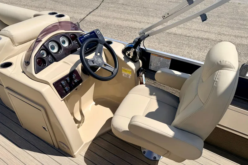 Slide: The Image of 2018 Sylvan 8522 Mirage Fish boat cockpit with steering wheel and beige captain's chair. - 38