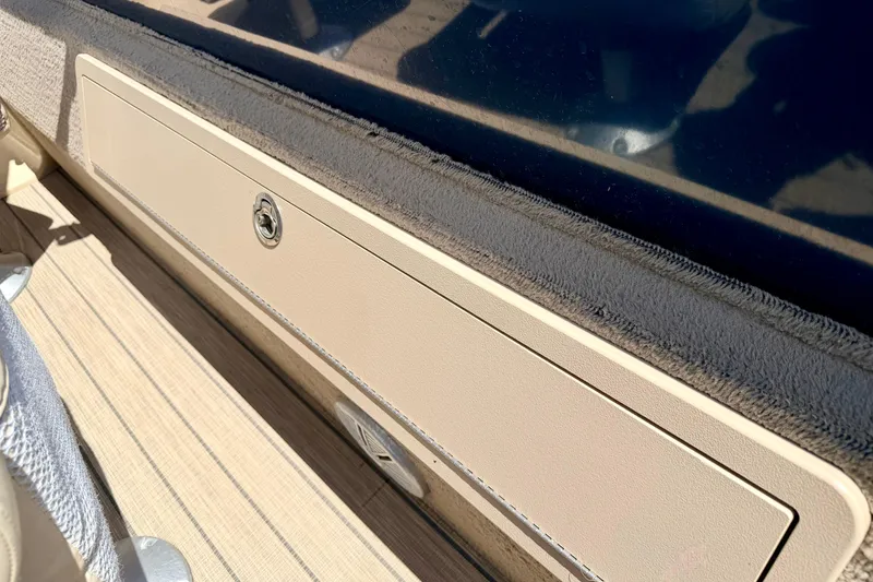 Slide: The Image of 2018 Sylvan 8522 Mirage Fish boat interior with beige storage compartment and wood-textured flooring. - 56