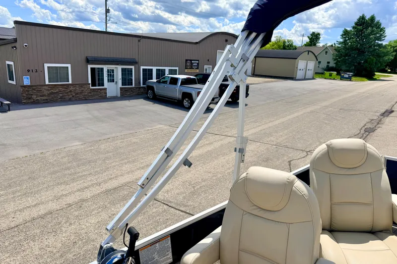 Slide: The Image of 2018 Sylvan 8522 Mirage Fish boat with beige seats, parked near a building. - 66