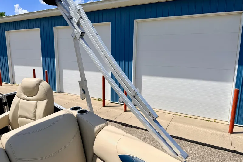 Slide: The Image of 2018 Sylvan 8522 Mirage Fish boat interior with beige seating and metal frame, near blue garage. - 67