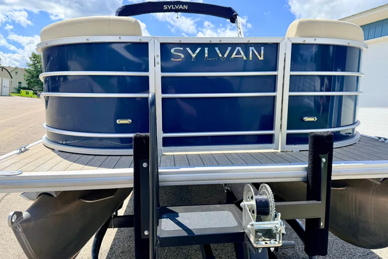Slide: The Image of 2018 Sylvan 8522 Mirage Fish pontoon boat on trailer, blue exterior, sunny day. - 8