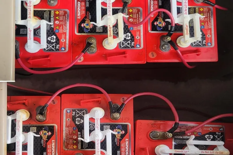 Slide: The Image of Red deep cycle batteries with connected cables in a 2008 Duffy Snug Harbor 18 boat. - 10