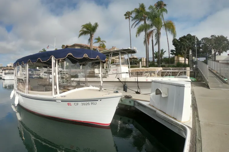 Slide: The Image of 2008 Duffy Snug Harbor 18 boat docked at marina with palm trees in background. - 13