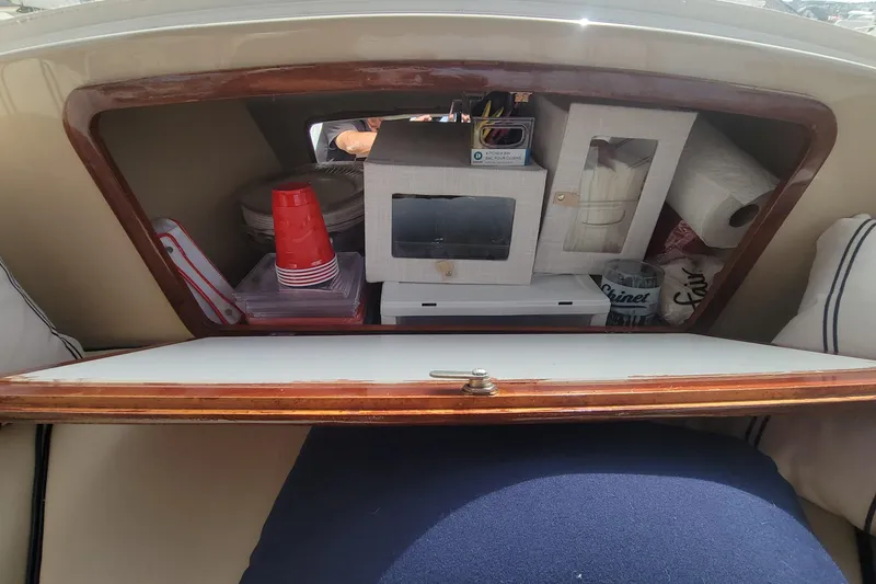 Slide: The Image of Storage compartment in a 2008 Duffy Snug Harbor 18 boat, containing cups and paper towels. - 6