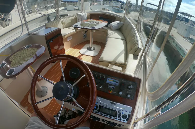 Slide: The Image of Interior of a 2008 Duffy Snug Harbor 18 boat with steering wheel and seating area. - 7