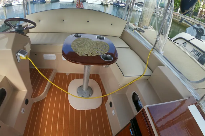 Slide: The Image of Interior of a 2008 Duffy Snug Harbor 18 boat with cushioned seating and a wooden table. - 8