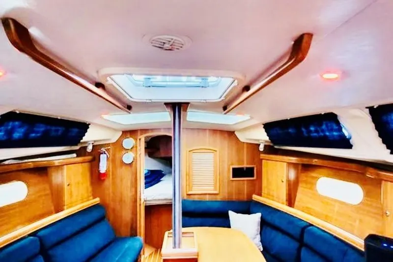 Slide: The Image of Interior of a 2002 Hunter 356 sailboat with wooden furnishings and blue seating. - 11