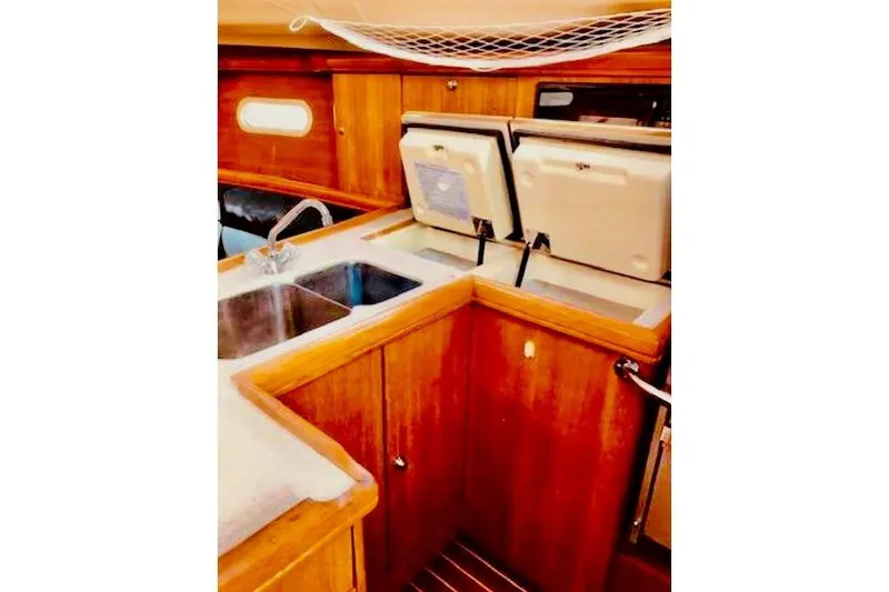 Slide: The Image of 2002 Hunter 356 yacht interior kitchen with wooden cabinetry and dual sinks. - 12
