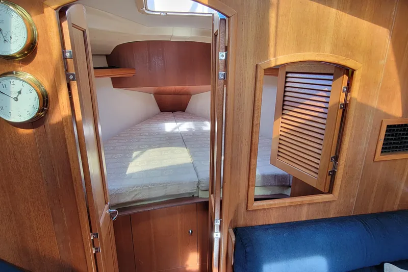 Slide: The Image of Interior cabin of 2002 Hunter 356 sailboat with wooden finish and cozy bed. - 2