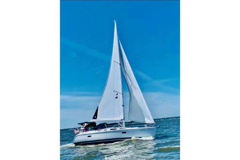 Slide: The Image of Sailing yacht Hunter 356, 2002 model, cruising on open water under clear blue skies. - 8