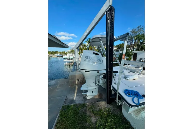 Slide: The Image of 2003 Hewes Redfisher 21 boat with Suzuki outboard motor docked by a waterfront. - 6