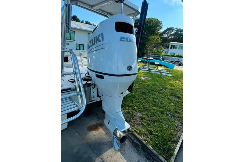 Slide: The Image of 2003 Hewes Redfisher 21 boat with Suzuki 200 outboard motor, parked outdoors. - 7