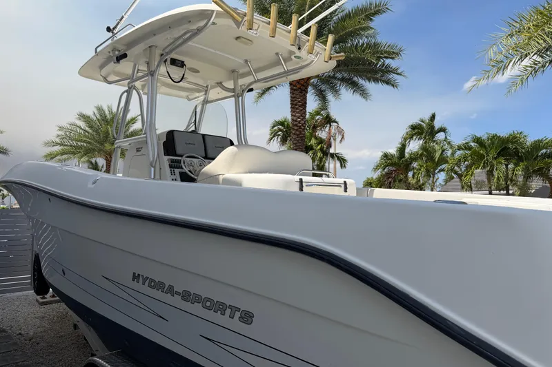 Slide: The Image of 2008 Hydra-Sports Vector 2900 CC boat docked, surrounded by palm trees under a clear sky. - 1