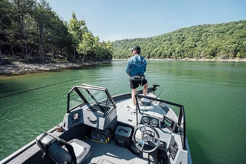 Slide: The Image of Man fishing on a 2027 Lowe Fishing Machine 1625WT boat in a scenic lake. - 8