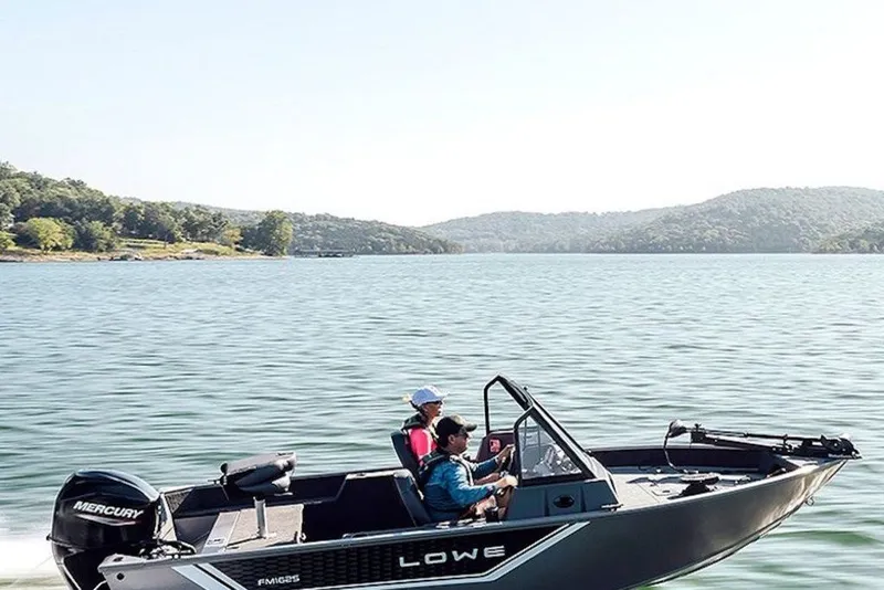 Slide: The Image of 2027 Lowe Fishing Machine 1625WT on a scenic lake with two passengers. - 4
