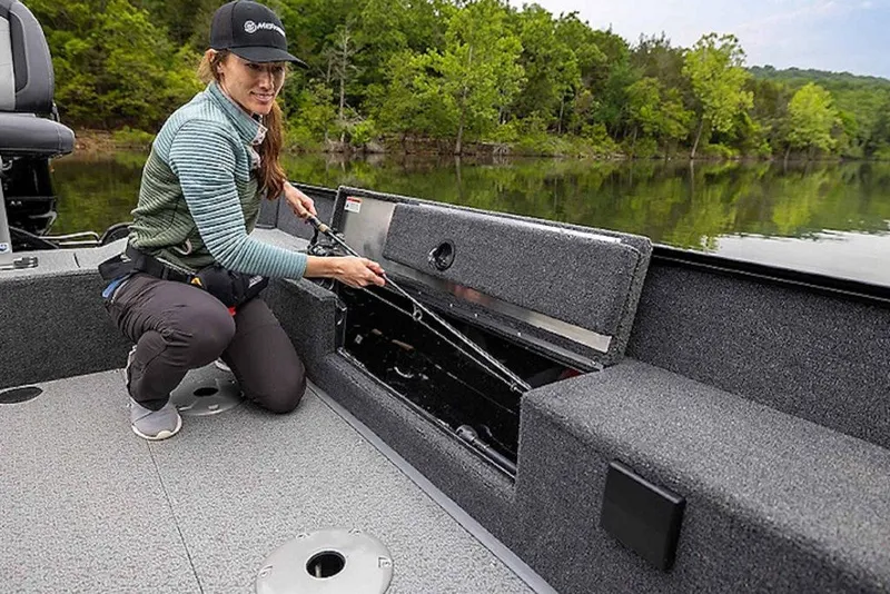 Slide: The Image of Woman organizing fishing rods on a 2027 Lowe Fishing Machine 1675WT boat. - 53