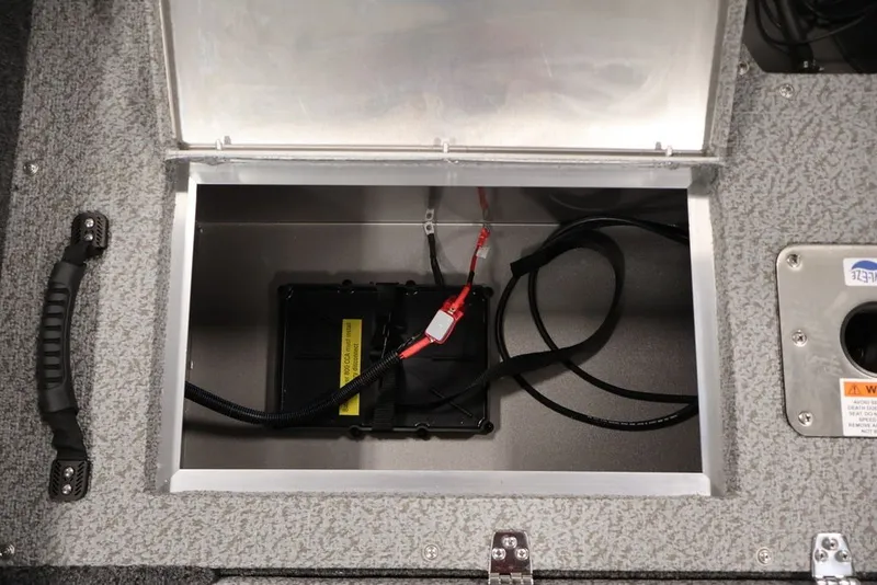 Slide: The Image of Battery compartment of 2027 Lowe Fishing Machine 1675WT boat, featuring wiring and secure storage. - 41