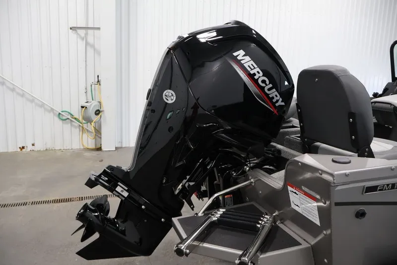 Slide: The Image of 2027 Lowe Fishing Machine 1675WT with Mercury outboard motor in a garage setting. - 48