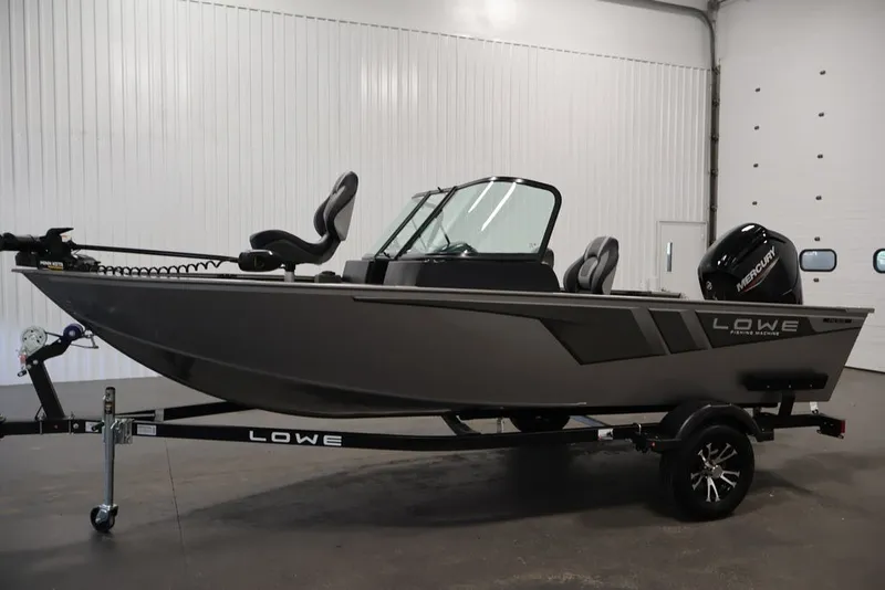 Slide: The Image of 2027 Lowe Fishing Machine 1675WT boat in showroom, side view with trailer. - 32