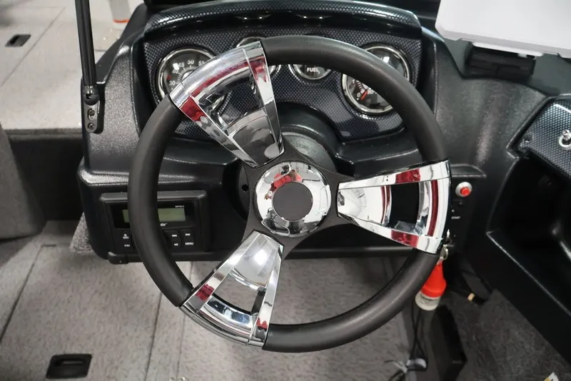 Slide: The Image of Steering wheel of 2027 Lowe Fishing Machine 1675WT boat, featuring chrome accents and dashboard gauges. - 29