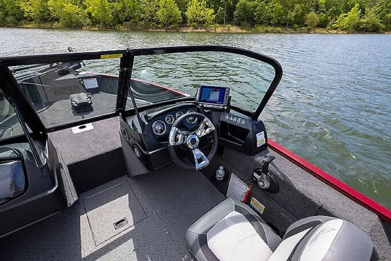 Slide: The Image of 2027 Lowe Fishing Machine 1675WT interior with steering wheel and control panel on a lake. - 58