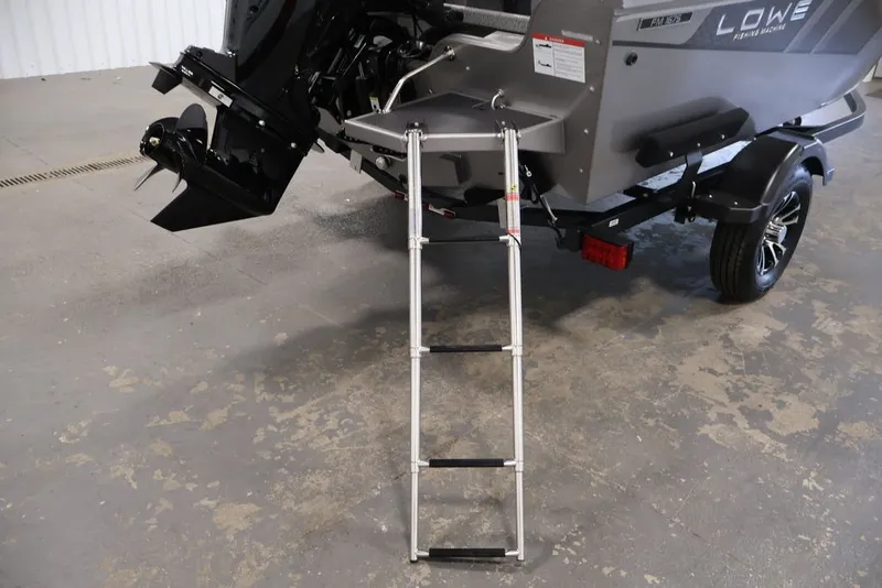 Slide: The Image of 2027 Lowe Fishing Machine 1675WT with ladder and motor, displayed indoors. - 51
