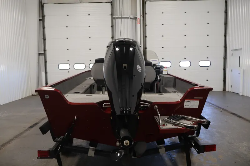 Slide: The Image of 2027 Lowe Fishing Machine 1775SC boat in a garage, rear view with motor. - 5